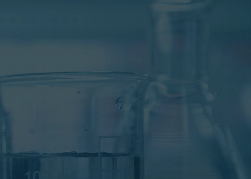 Close-up of laboratory glassware with a blue overlay for analytical testing and lab services.
