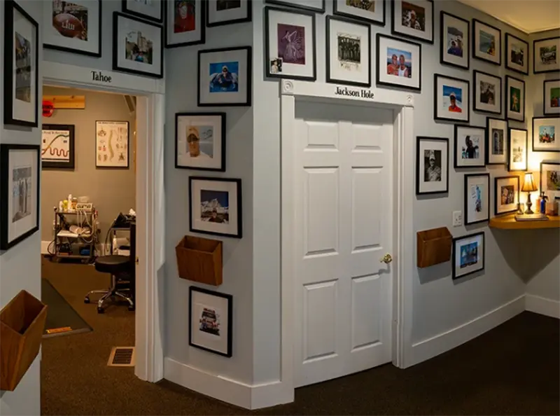 BeWell Chiropractic office hallway with framed photos, treatment room entrances, and clinic decor.