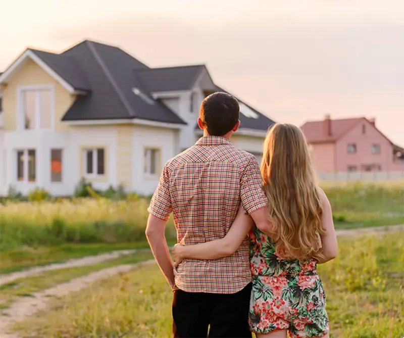 Couple looking at a new home at sunset for a home insurance or real estate coverage case study.